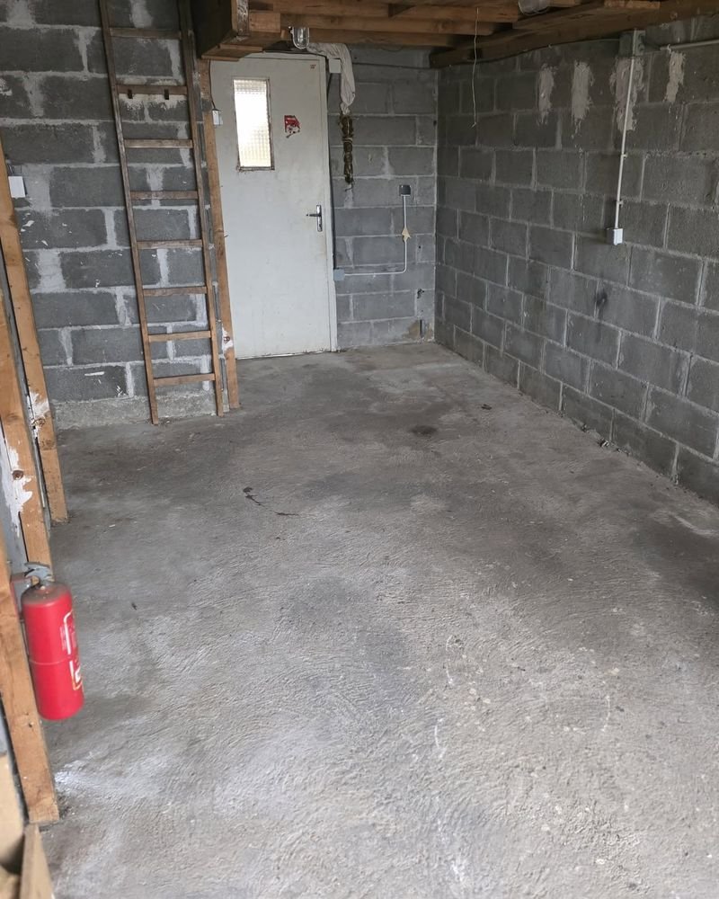 Remise aux murs en parpaings entièrement vidée, sol balayé
